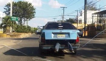 Los dominicanos somos así: hombre montado en el baúl de un carro