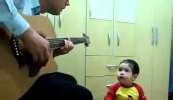 Niño de 2 años canta con su papá y toca la guitarra 