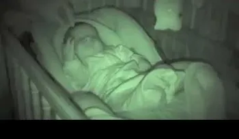 El papá coloca pone las manos del bebé bajo la manta, y la cámara de la niñera ha hecho reír a todos 