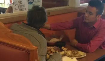 Mesero de Georgia ayuda a comer a hombre sin manos