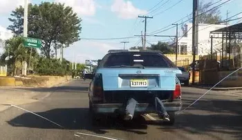 Los dominicanos somos así: hombre montado en el baúl de un carro