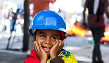 Una niña sonríe en medio del caos de las protestas en Venezuela