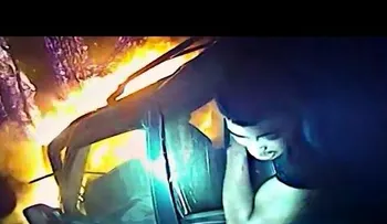 Graban a un policía salvando a un hombre de un coche en llamas