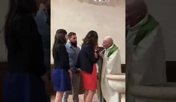 Un sacerdote golpea a un bebé en un bautizo