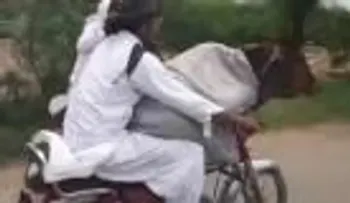 Un hombre pasea en moto con su vaca 