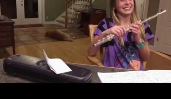 La niña quiere practicar flauta, pero un perro gruñón no parece gustarle la idea 