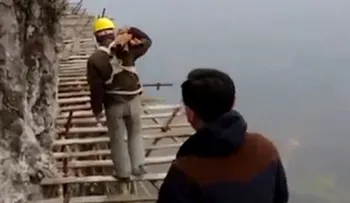 Obreros chinos arriesgan su vida para construir una pasarela de vidrio en una montaña a 1.700 metros de altura