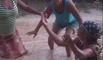 Mujeres en Villa Riva se bañan en charcos para exigir arreglo de calles