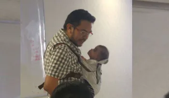 Profesor carga al bebé de su alumna para que ella pueda tomar apuntes