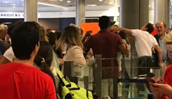 Empleado de un aeropuerto golpea a un pasajero con un bebé en brazos