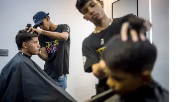 Jóvenes venezolanos emprenden barbería en Caracas