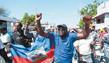 Turba de haitianos propinan golpes a empleados de Migración y destruyen vehículo.