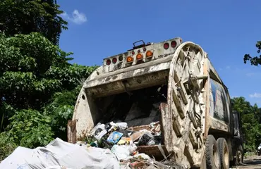 Camiones de basura averiados convierten calle en La Isabela en un foco de contaminación