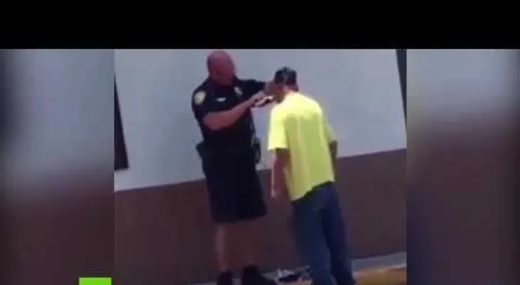 Un policía ayuda a un sintecho a afeitarse la barba para que le den un empleo