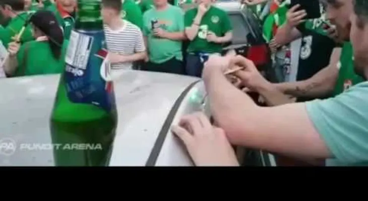 Con cerveza y cánticos hinchas irlandeses intentan reparar un auto que habían dañado
