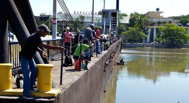 Pescadores usan puente flotante sobre el Ozama