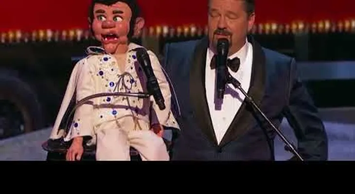 Le pide que cante una canción de Elvis, y el muñeco canta "Blue Christmas"  