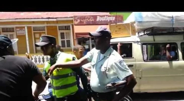 Un hombre le da un galletón a un agente de AMET