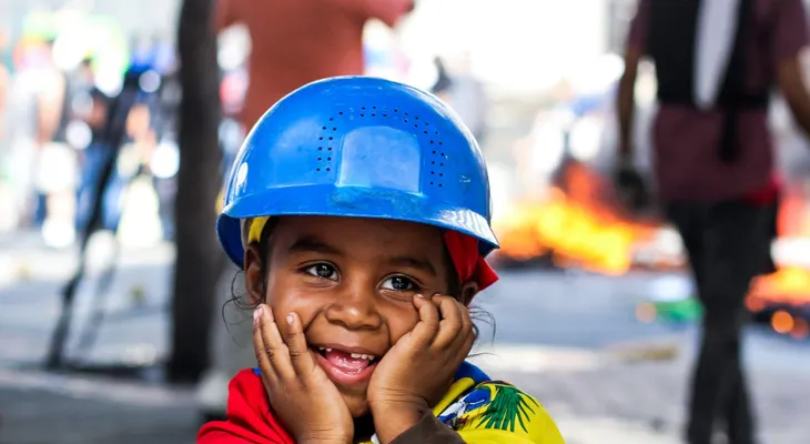 Una niña sonríe en medio del caos de las protestas en Venezuela