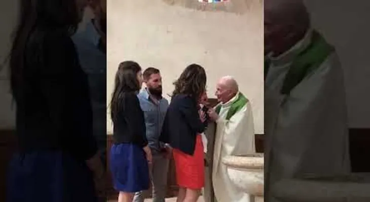 Un sacerdote golpea a un bebé en un bautizo