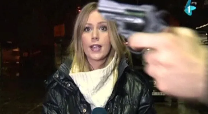 Esta reportera amenazada con una pistola en la cabeza sigue hablando como si nada... (VIDEO)
