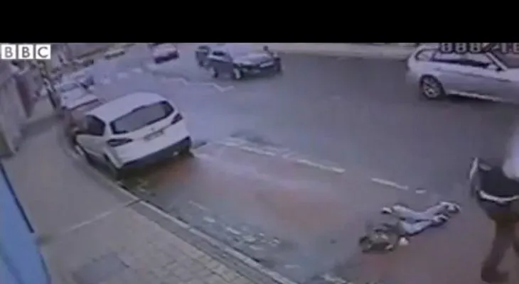 Policías arrastran a una mujer hacia el borde de la calzada y se van en un coche no identificado