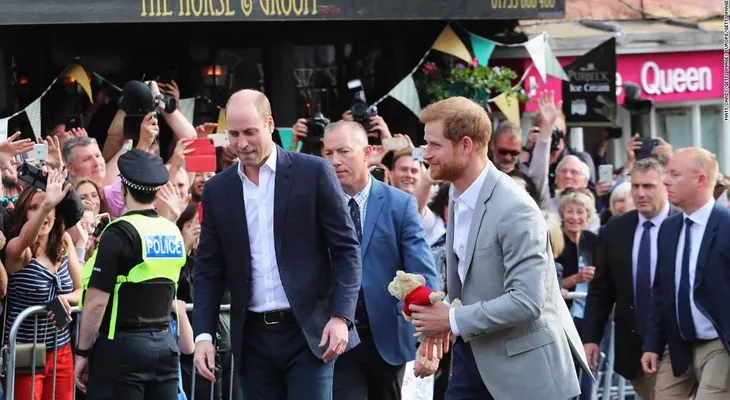 Los príncipes Enrique y Guillermo saludan a sus admiradores en la víspera de la boda real