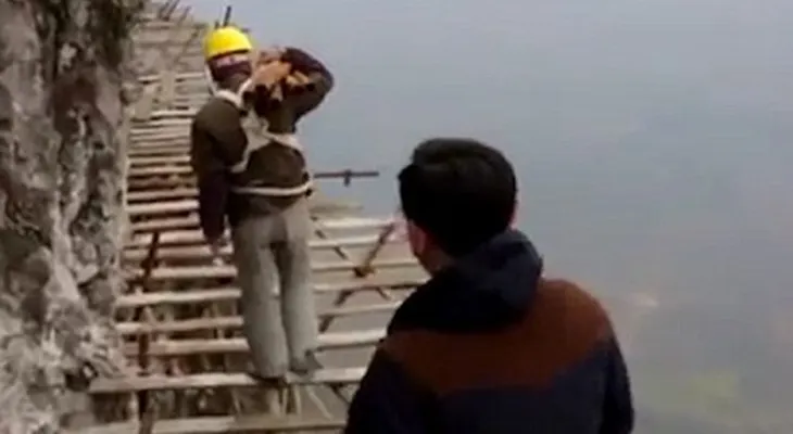Obreros chinos arriesgan su vida para construir una pasarela de vidrio en una montaña a 1.700 metros de altura