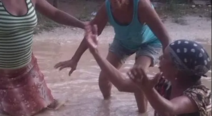 Mujeres en Villa Riva se bañan en charcos para exigir arreglo de calles
