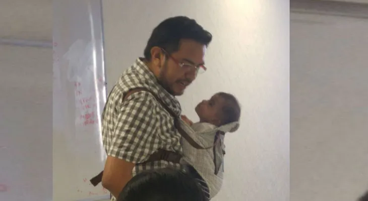Profesor carga al bebé de su alumna para que ella pueda tomar apuntes