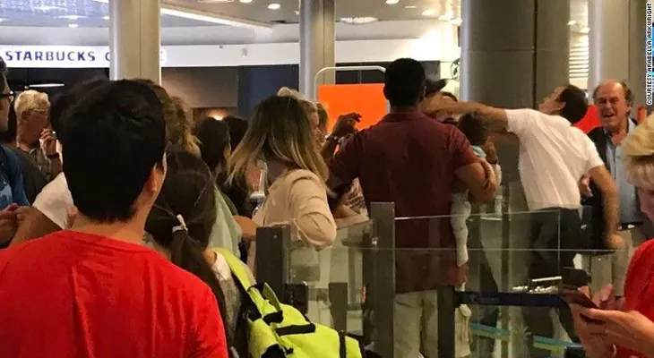 Empleado de un aeropuerto golpea a un pasajero con un bebé en brazos