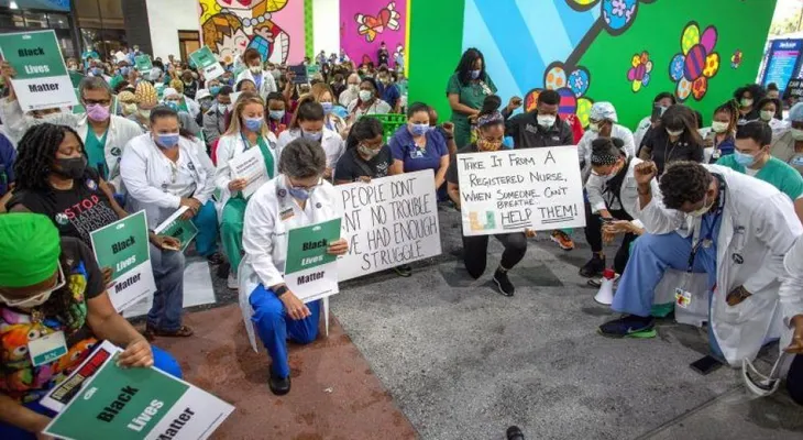 De rodillas, médicos y enfermeras de Miami honran a Floyd