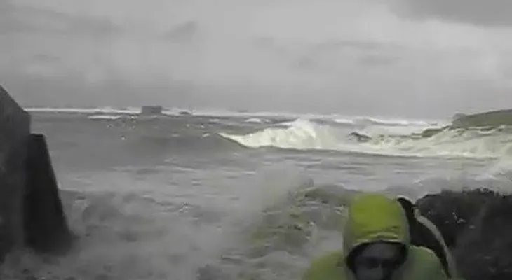 Una pareja es arrastrada por las olas en medio de una tormenta