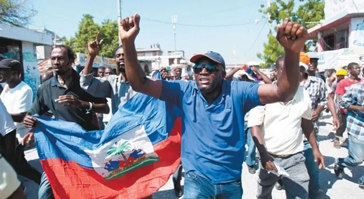 Turba de haitianos propinan golpes a empleados de Migración y destruyen vehículo.